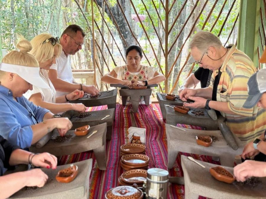 Guests grinding cacao on stone metates