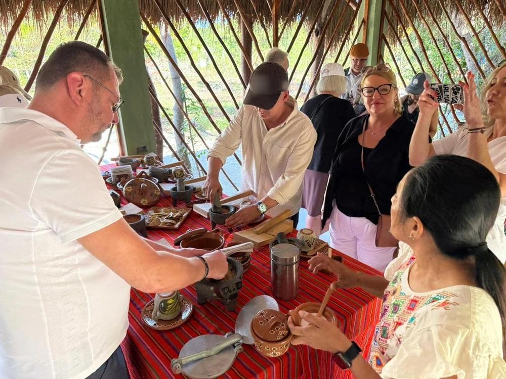 Guests around the kitchen table, grinding and cooking