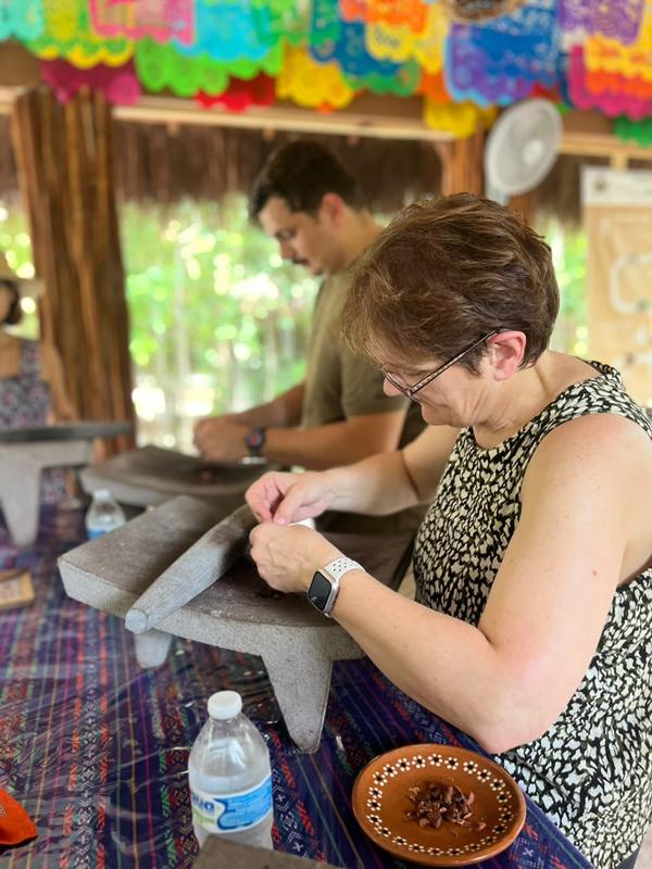 A guest grinding cacao on a stone metate